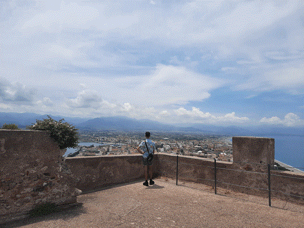 Picture of a man in a castle, looking to the panoramic view of Sicily's land
